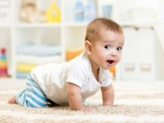 At what age does the child begin to crawl, and what exercises contribute to this?