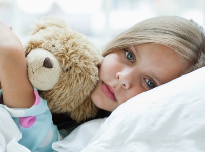 La niña cayó enferma - acostada en la cama.