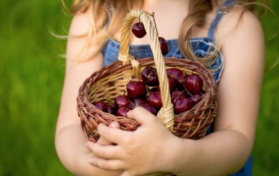 Niña comiendo cereza