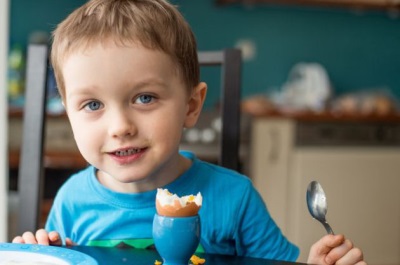 Bambino che mangia le uova