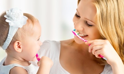 Mom and daughter brush their teeth