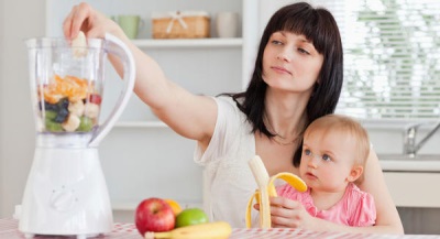 Mamma con bambino, cibo in un frullatore