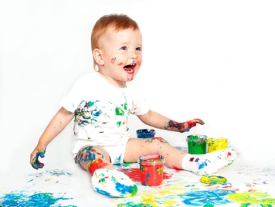 Un niño de 1,5 años jugando con pinturas.