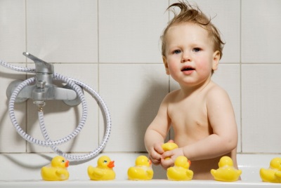 Bebé con juguetes en el baño.