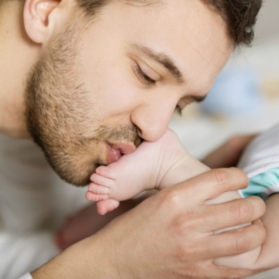 Dad kisses baby's foot in 1 month