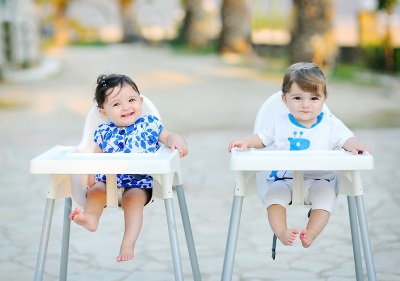 Niños 11 meses en sillas para alimentación.