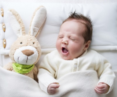 Baby 2 months sleeping with a toy