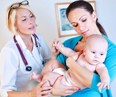 Bebé de 2 meses en los brazos de un médico.