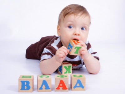 Un niño de 6 meses se mete un juguete en la boca.