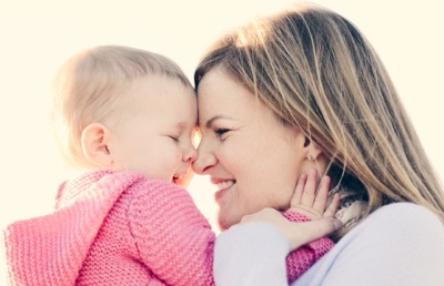 Bebé de 8 meses mamá en sus brazos.