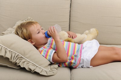 L'enfant boit de l'eau avec de l'acétone élevée.