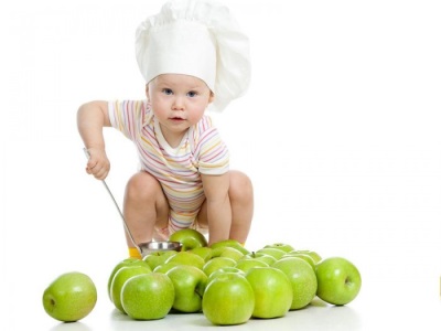 Baby spielt mit Äpfeln