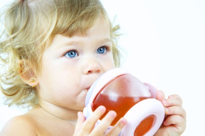 El niño bebe compota de frutos secos.