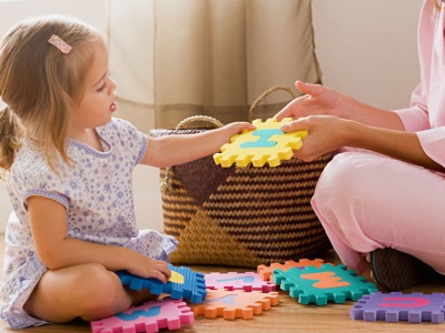 Mom plays with the child in puzzles