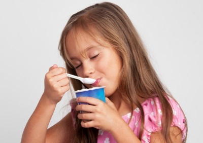 Niña comiendo yogurt