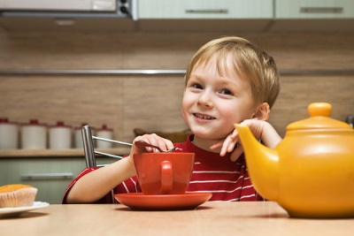 Bambino al tavolo con il tè