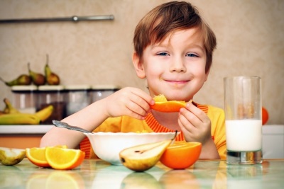 Ragazzo che mangia arancio