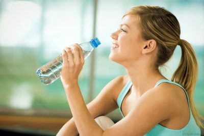 La ragazza teenager beve l'acqua