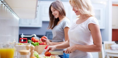 Mamá cocina con su hija adolescente