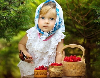 Bambino con lamponi in cestini