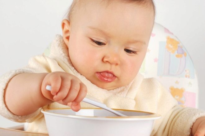 The child eats with a spoon