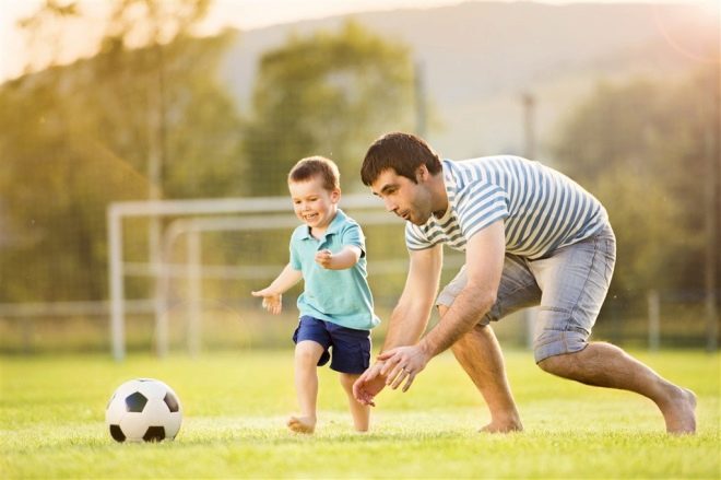 Juegos infantiles activos con papá en la pelota.