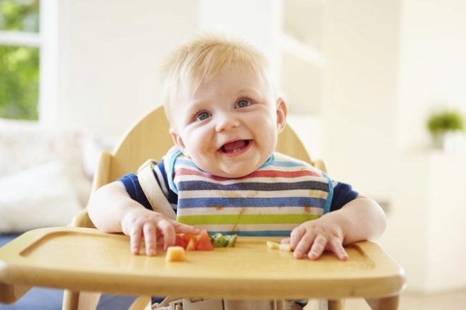 Baby eats at 1 year on a highchair